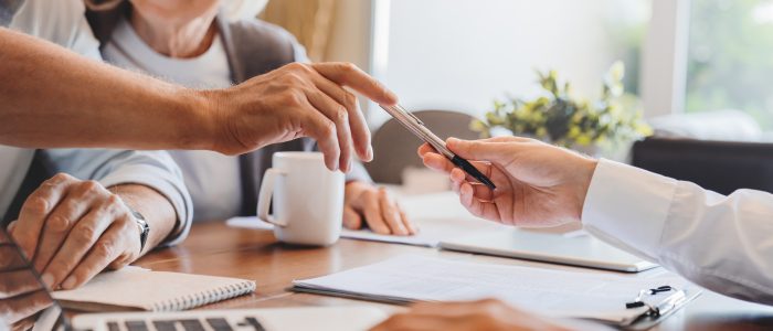 Älteres Ehepaar unterschreibt Vertrag für Hausverkauf