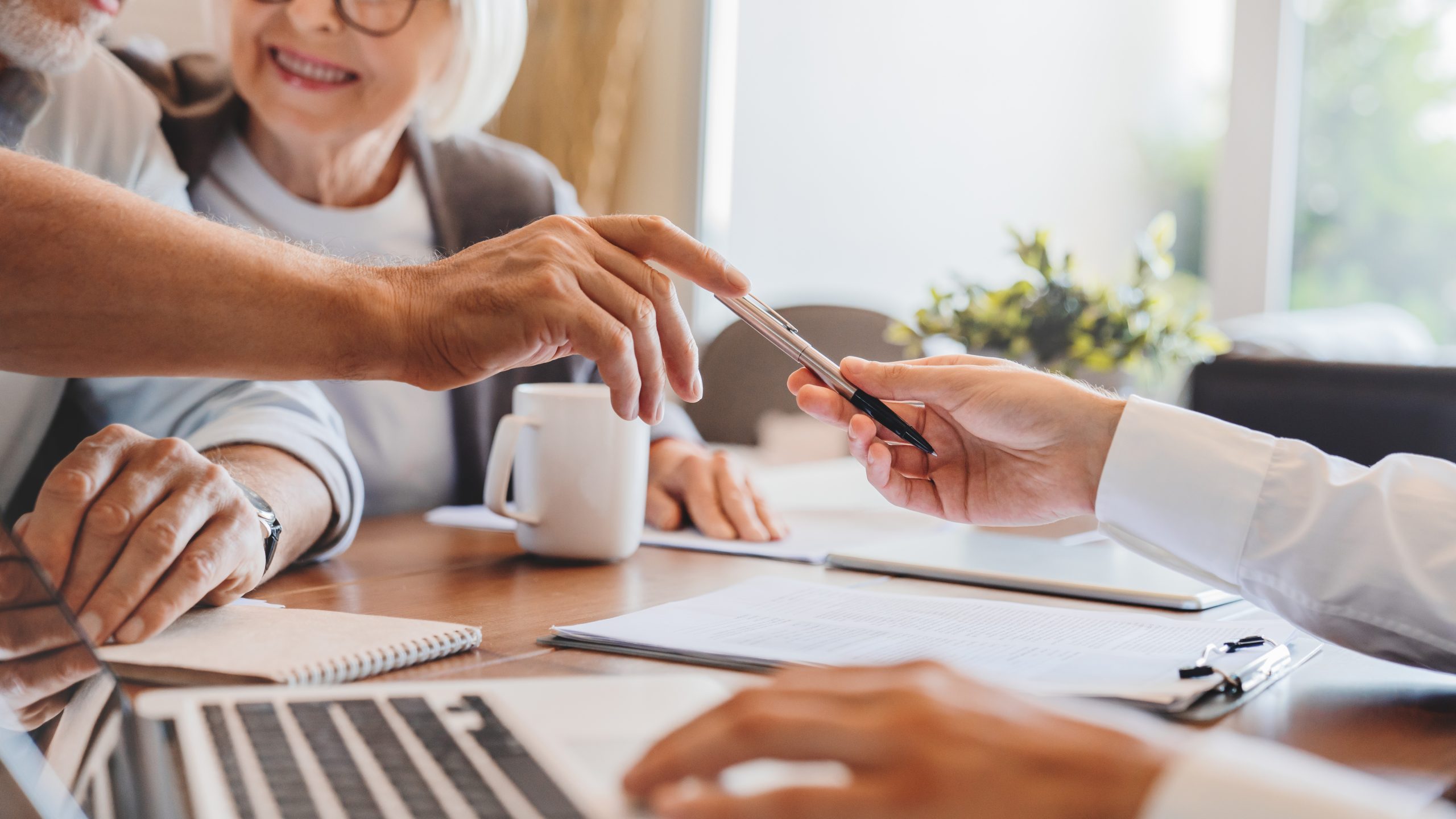 Älteres Ehepaar unterschreibt Vertrag für Hausverkauf